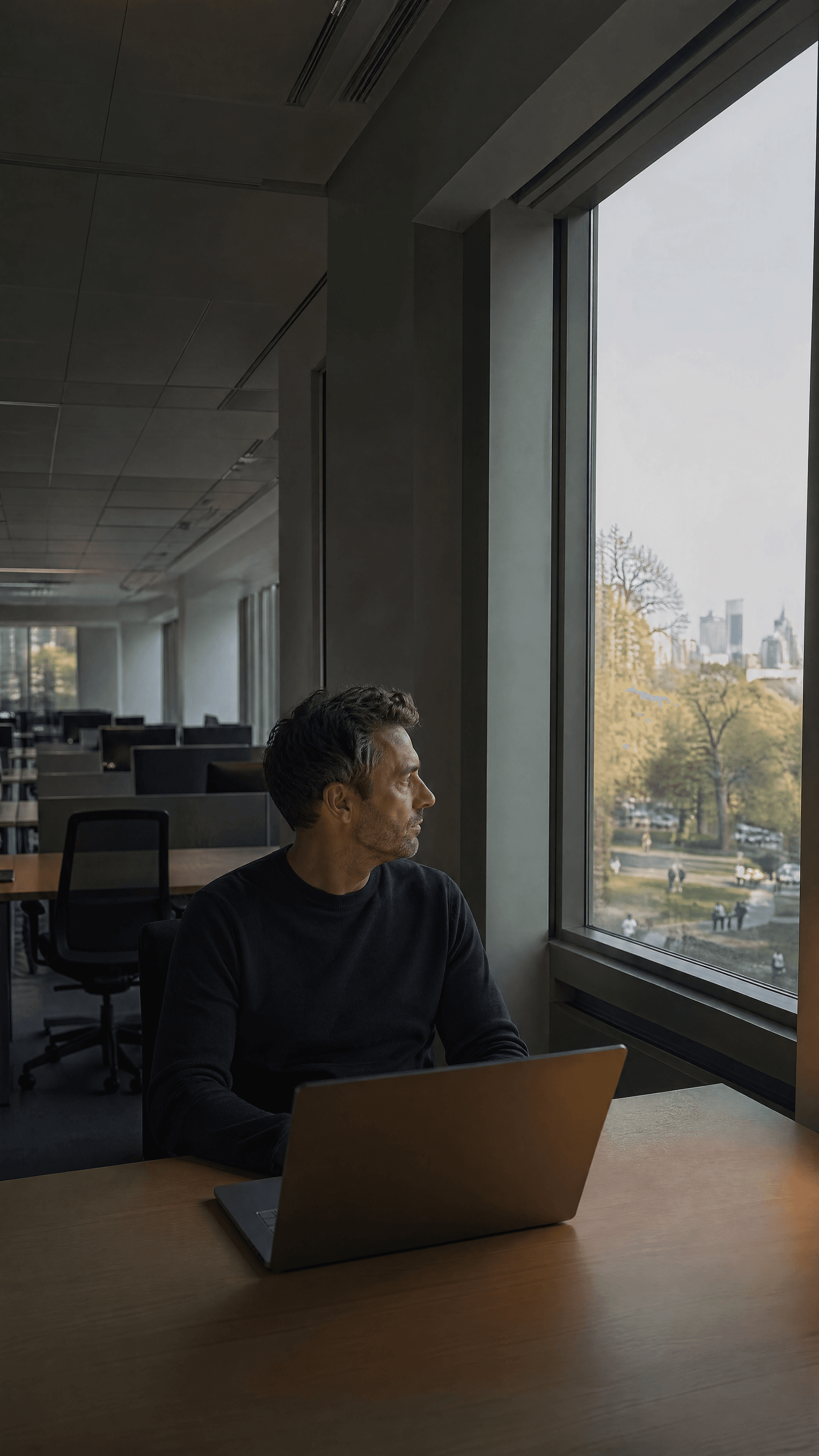 Man at a desk by an office window.